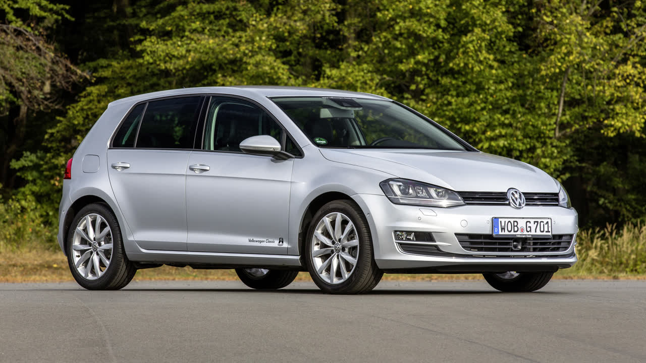Sølvgrå Volkswagen Golf med tyske nummerplader parkeret ved en skovkant, en af de hyppigst værdifastsatte brugte personbiler hos Motorstyrelsen